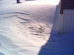 wind sculpted drift around the corner of a house